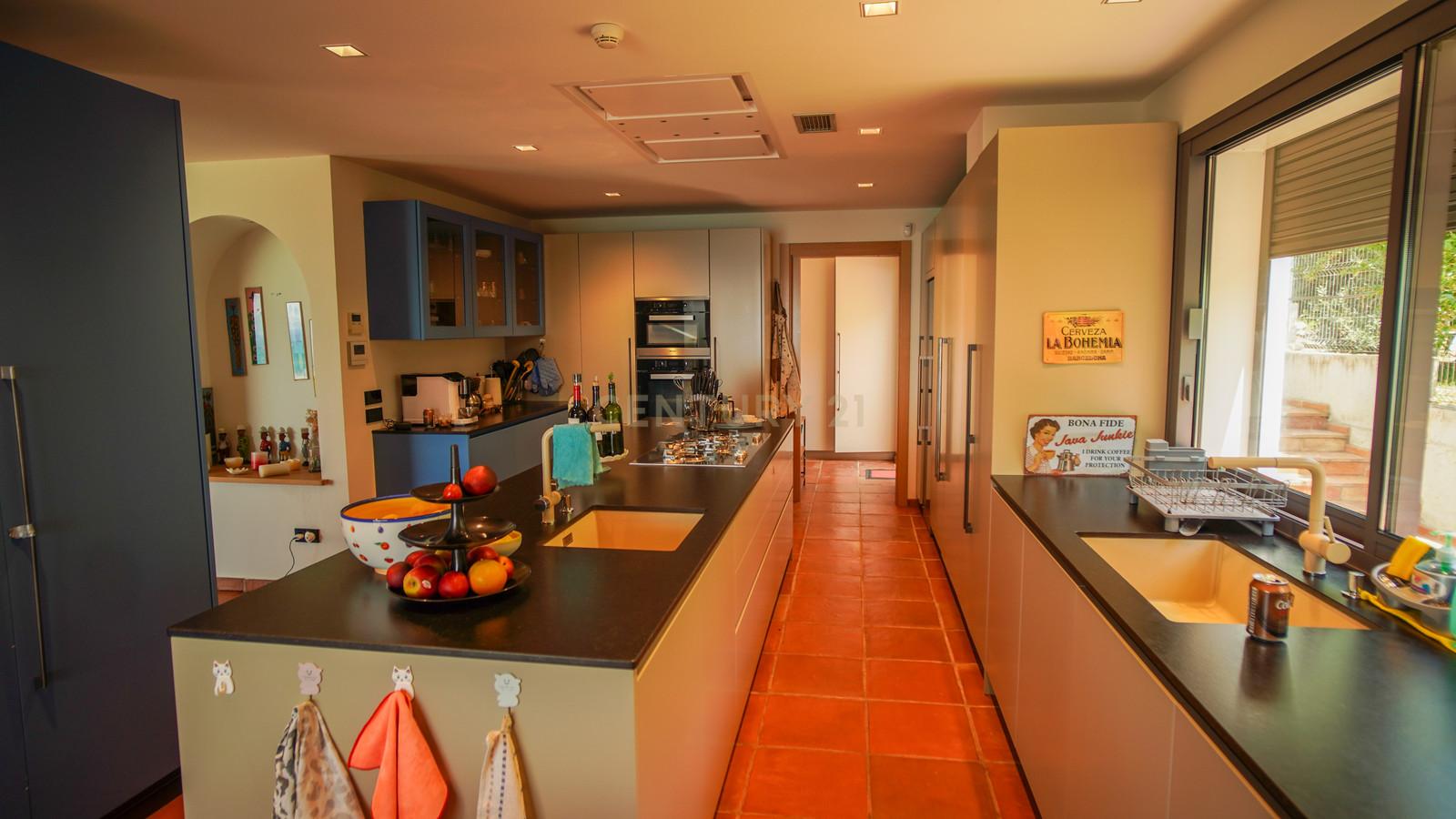 Everyday kitchen of Villa Can Bonita with deep stone counters and wide windows onto the Mediterranean.