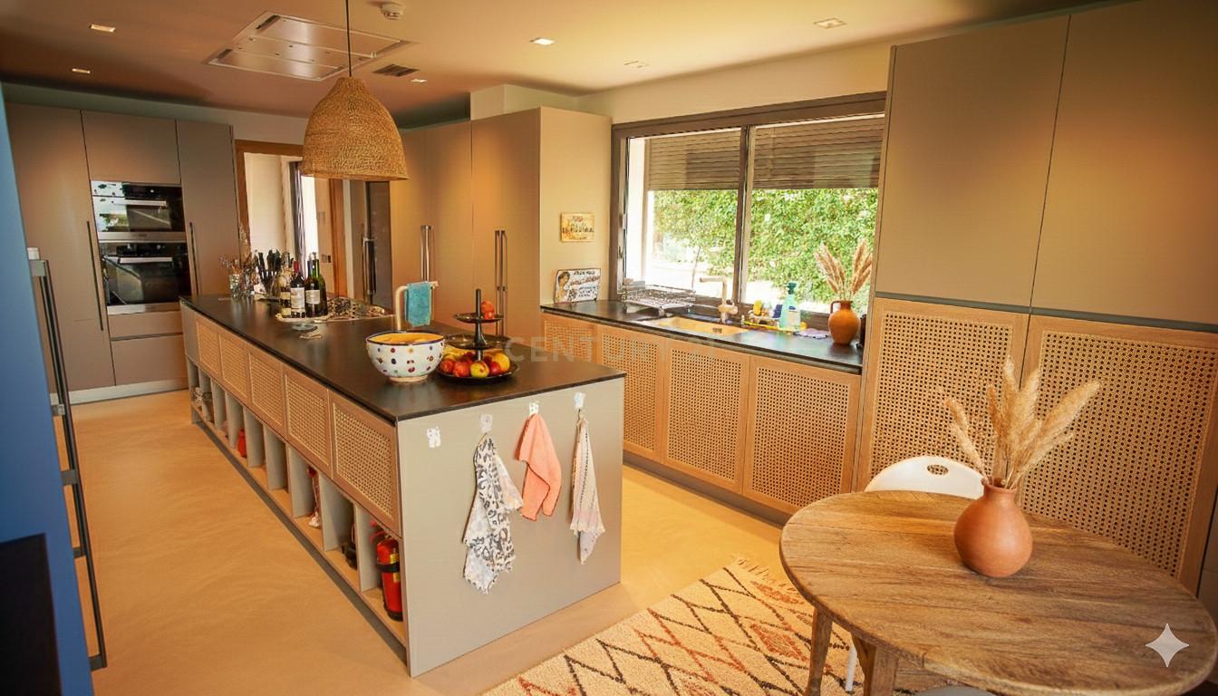 Chef's kitchen at Villa Can Bonita with central island in oak and stone, twin ovens and integrated wine cellar.