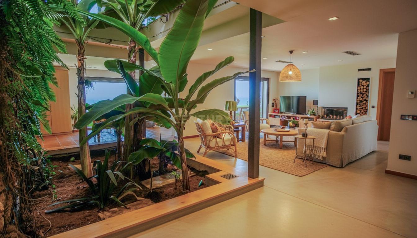 Sea-facing sitting room of Villa Can Bonita with linen sofas, oak joinery and sliding glass walls opening to the terrace.