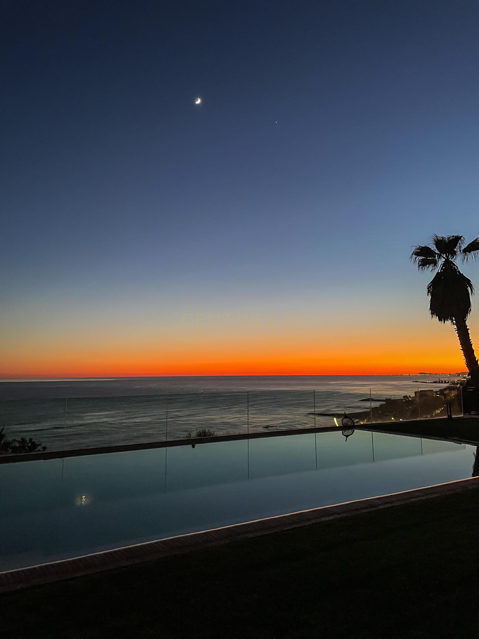 Sunset over Villa Can Bonita's infinity pool, sea and sky merging into a single horizon above the Costa Barcelona coast.