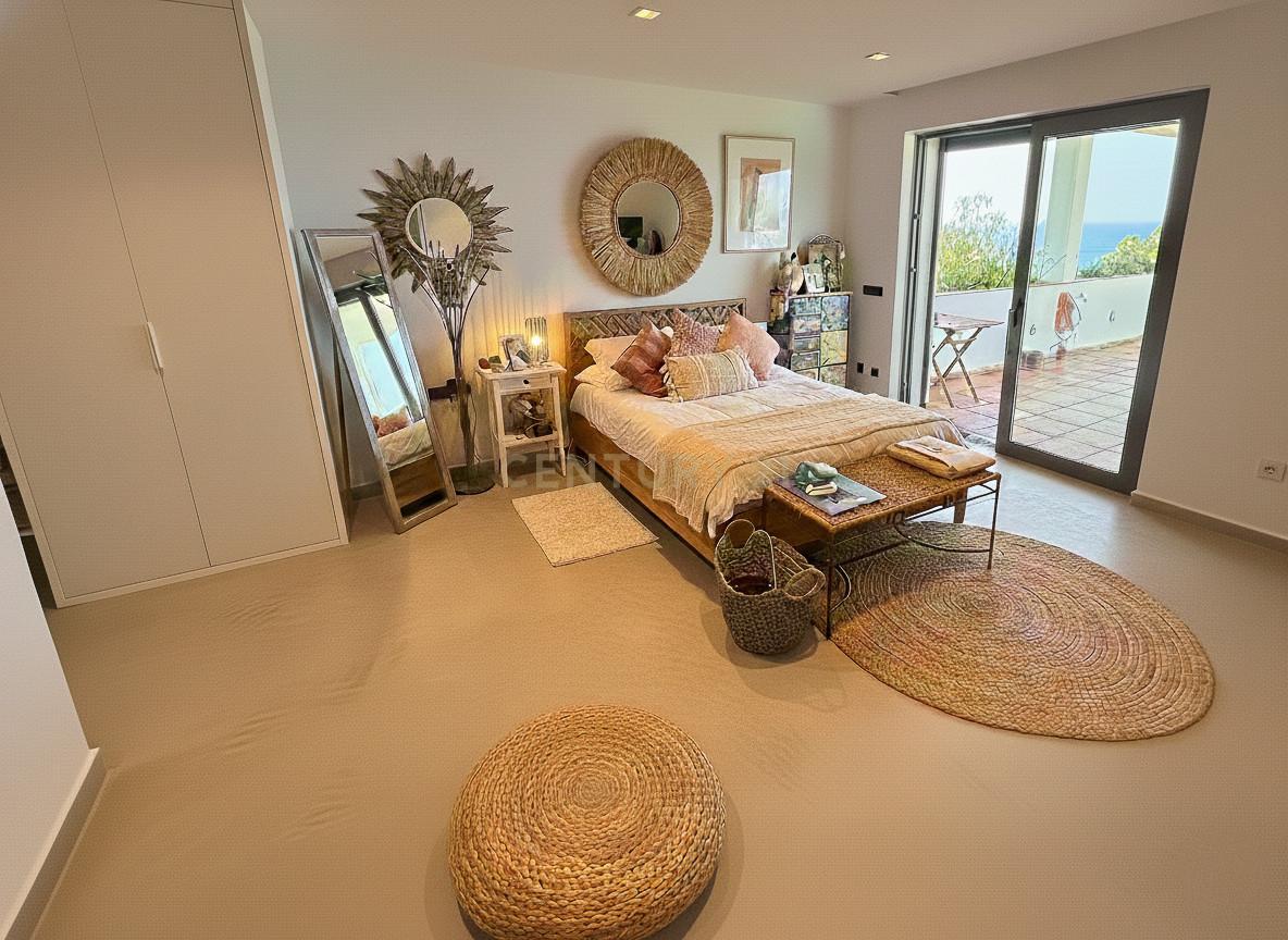 Guest suite at Villa Can Bonita with woven textures, linen bedding and private access to a sea-view terrace.